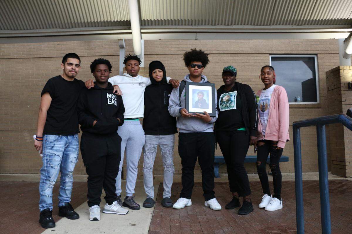 Ja’Shawn Poirier’s friends stood next to another close friend, Dwayne Scott (third from the right), a student at Lamar High School, and Poirier’s mother and sister, Roshone and Nautica Jacob, at his memorial Friday, April 28, 2023.