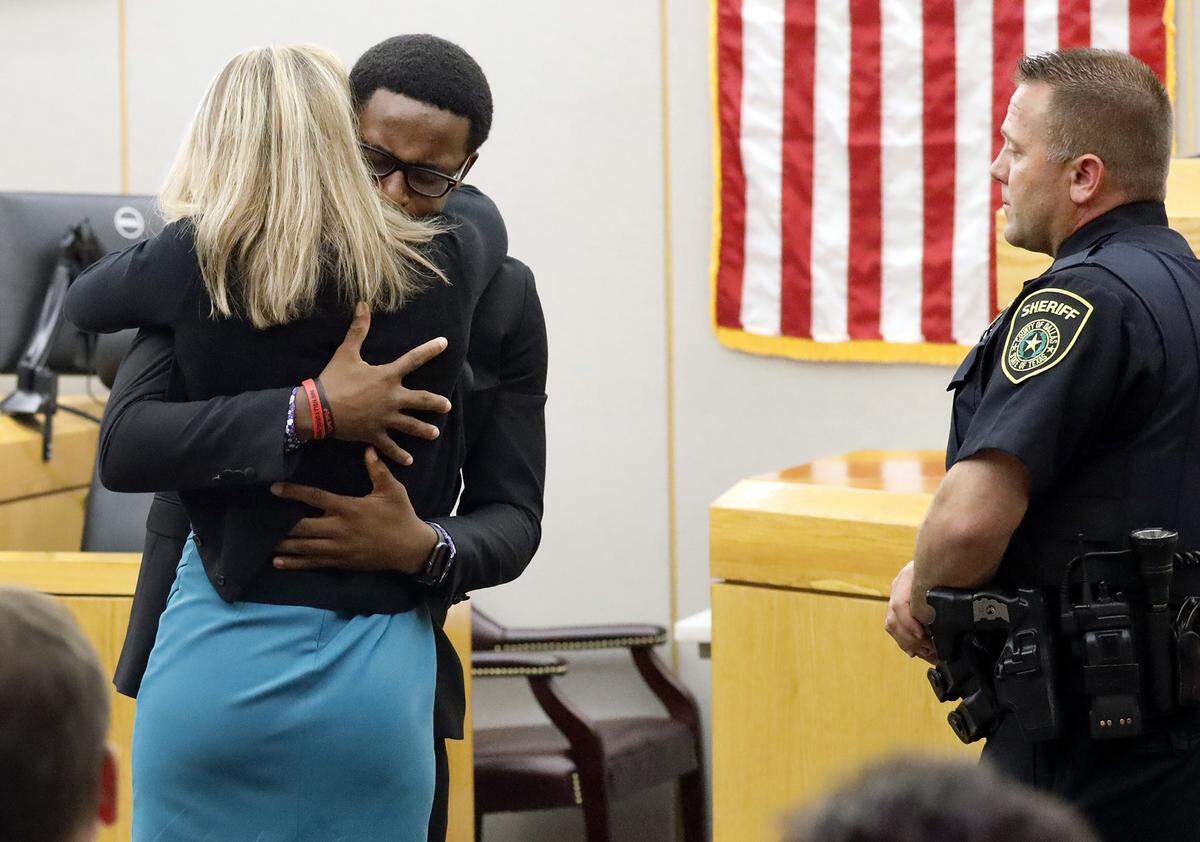 Botham Jean’s younger brother Brandt Jean hugs convicted murderer and former Dallas Police Officer Amber Guyger after delivering his impact statement to her after she was sentenced to 10 years in prison, Wednesday, Oct. 2, 2019, in Dallas. Guyger shot and killed Botham Jean, an unarmed 26-year-old neighbor in his own apartment last year. She told police she thought his apartment was her own and that he was an intruder. (Tom Fox/The Dallas Morning News via AP, Pool)