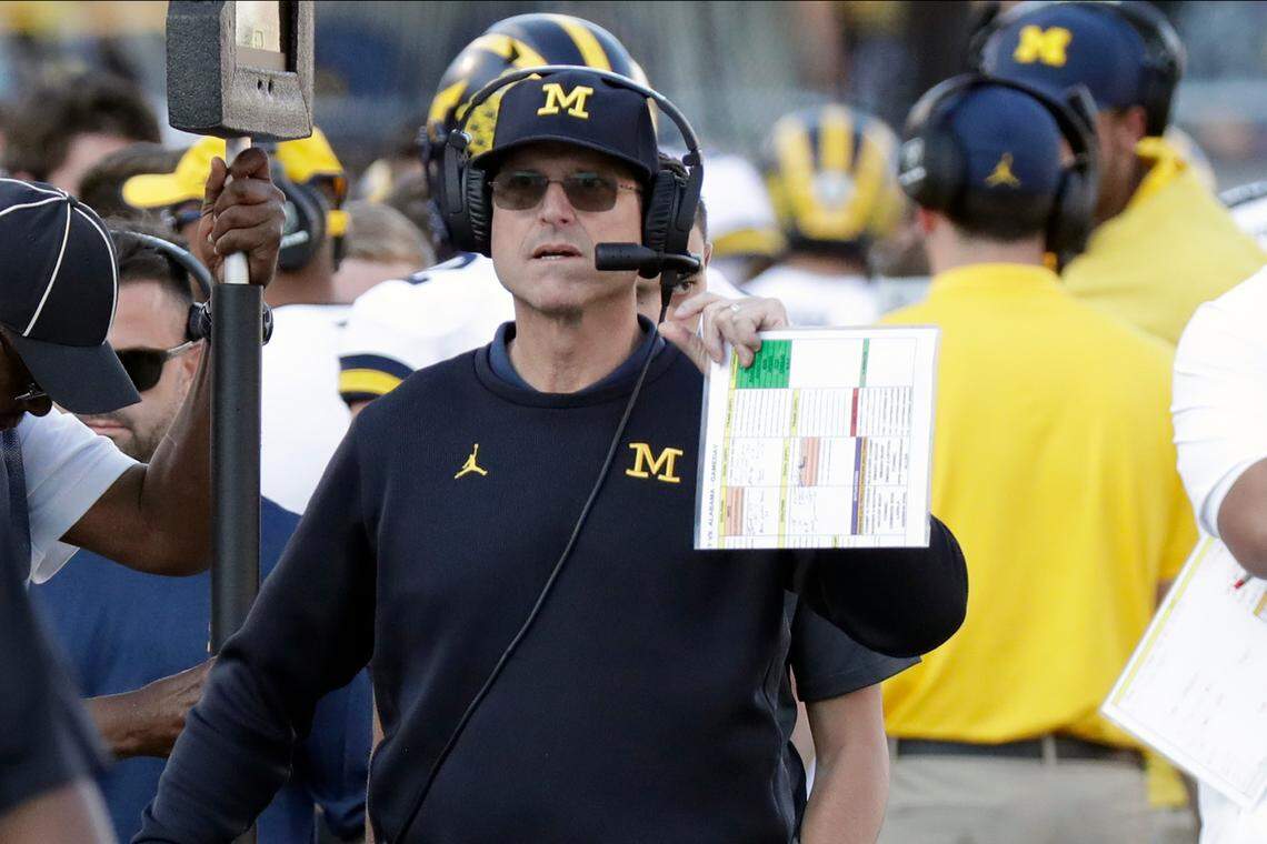 FILE - In this Jan. 1, 2020, file photo, Michigan head coach Jim Harbaugh paces the sideline during the second half of the Citrus Bowl NCAA college football game against Alabama in Orlando, Fla. Michigan has decided to stick with Harbaugh. He has finalized a new, five-year deal with a base salary of $4 million per year. He can make as much as $8 million with incentives, according to a person familiar with the contract who spoke to The Associated Press. (AP Photo/John Raoux, File)