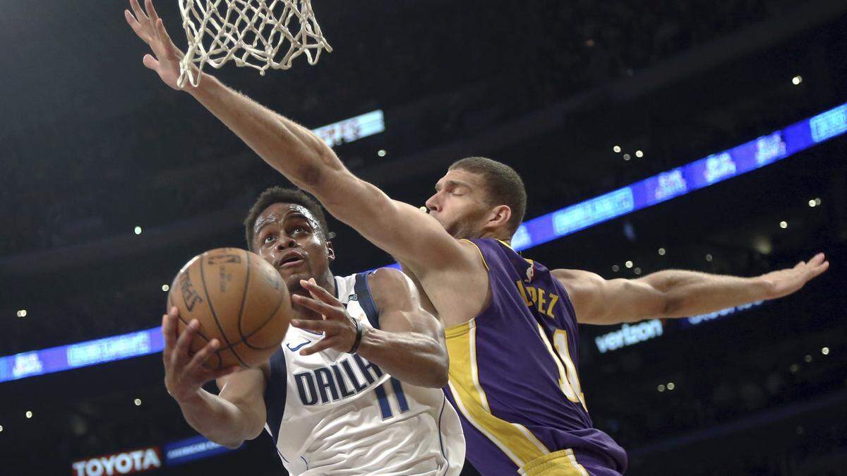 Mavericks guard Yogi Ferrell (11) attempts a shot as Los Angeles Lakers center Brook Lopez (11) defends during the first half of Tuesday's NBA game in Los Angeles.