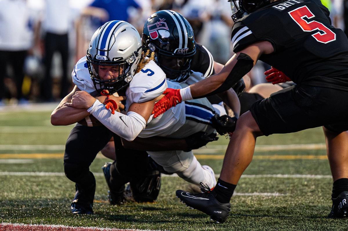 Burleson Centennial quarterback Jacob Torres (5) dives between Burleson defenders for a touchdown in the first quarter of a the 2024 Boot Bowl game at BISD Stadium in Burleson on Friday, Aug. 30, 2024.