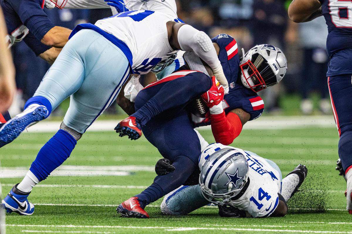 Patriots running back Ezekiel Elliot (15) gets tackled in the first half of an NFL game between the Dallas Cowboys and New England Patriots at AT&T Stadium in Arlington on Sunday, Oct. 1, 2023.