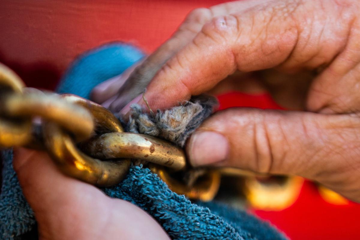 A Clydesdale handler polishes a gold chain in preparation to stroll down the stockyards on Friday, July 12 at Billy Bobs Texas.