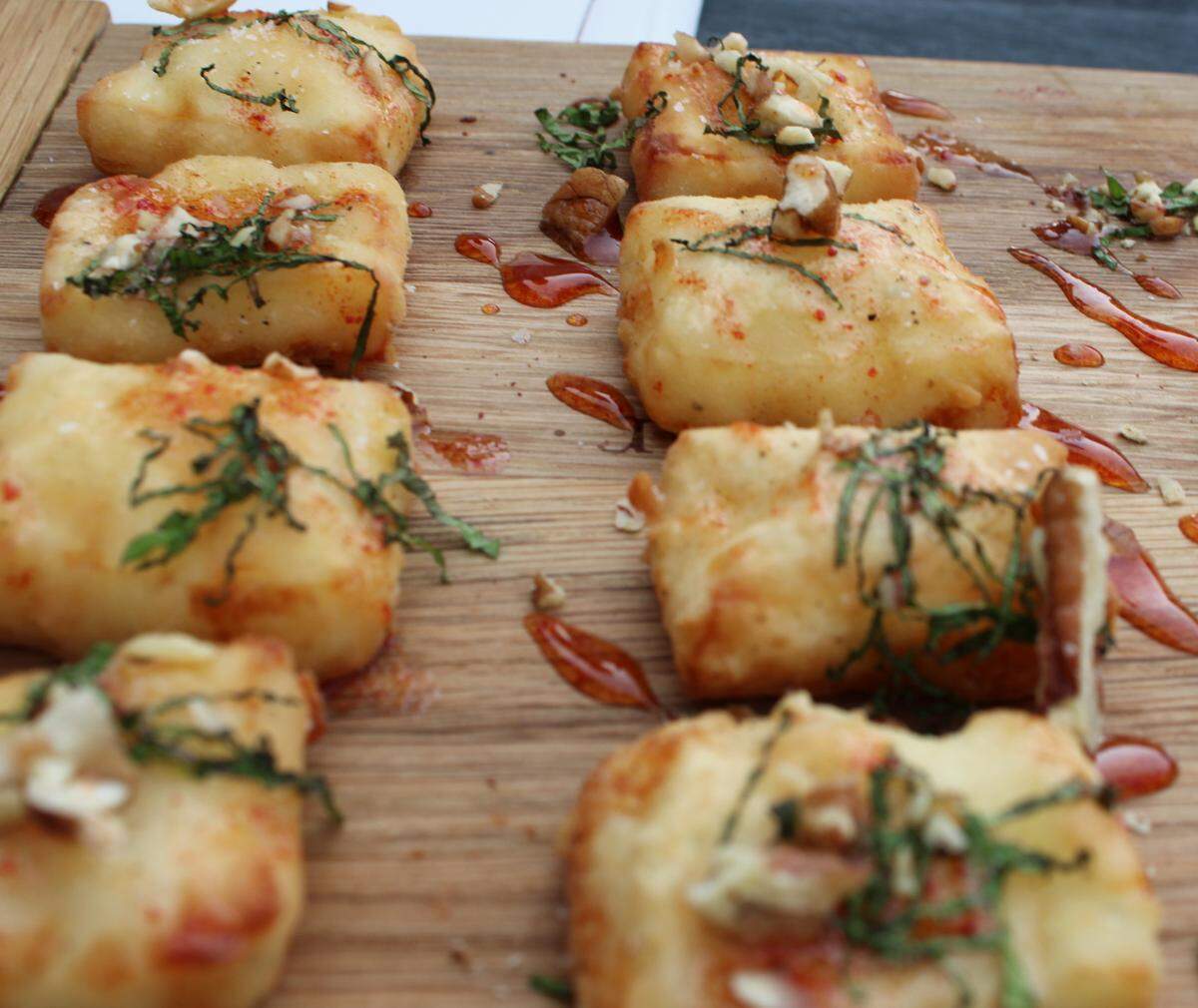 A sampling of Crispy Halloumi, a Greek grilling cheese, topped with pecans and watermelon molasses.