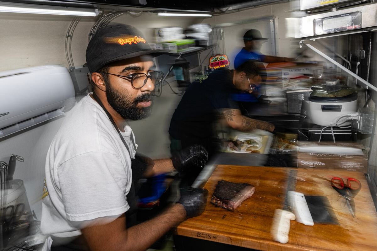 Zain Shafi, the owner of Sabar BBQ, and his pit hands Usama Khalid, middle, and Salman Shafi scramble to get customers orders ready at the Sabar BBQ smoker trailer parked at the corner of E Vickery Street and S Main Street near downtown Fort Worth on Saturday, Aug. 31, 2024.