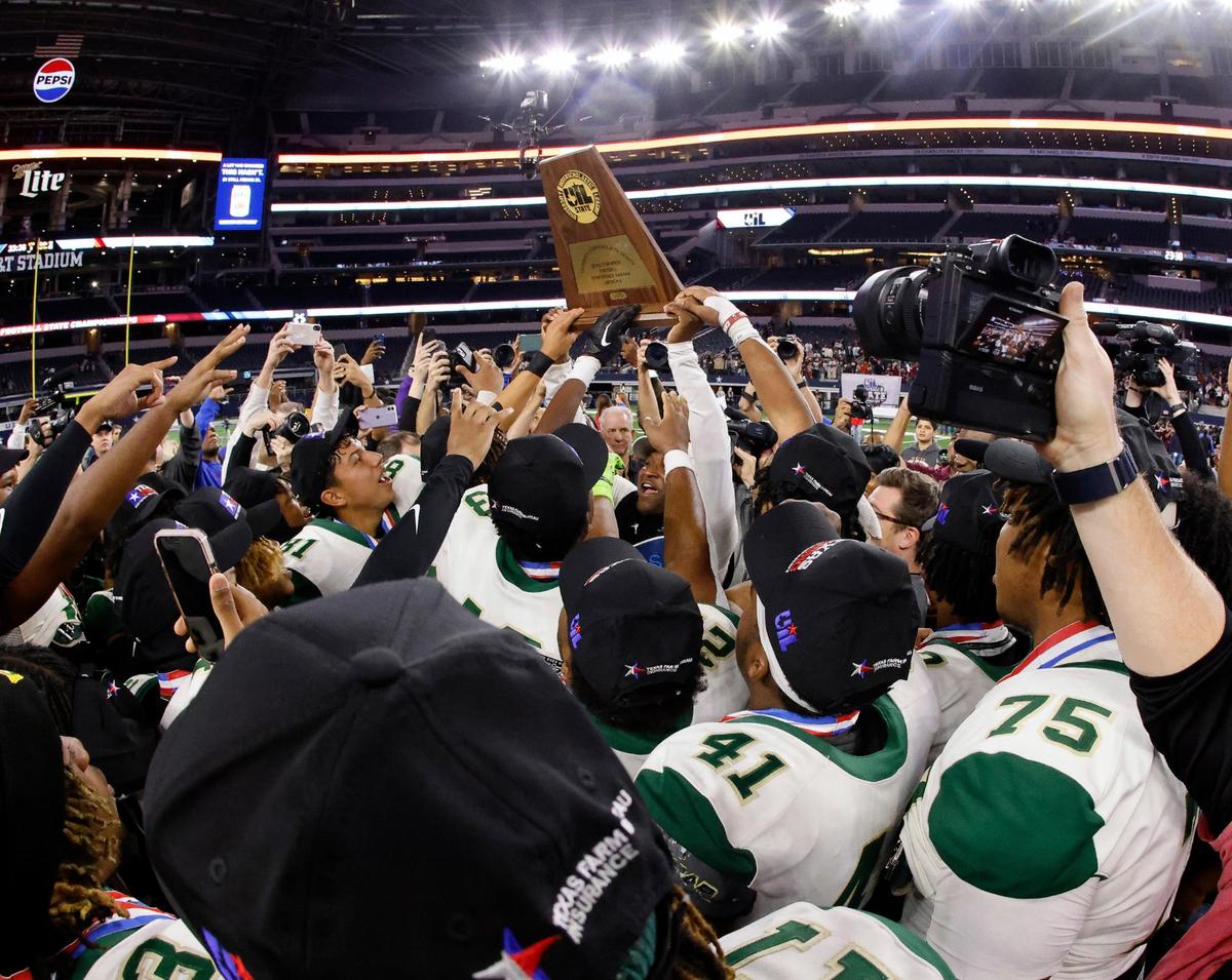 DeSoto Eagles players reach in to touch the championship plaque during the second half of the UIL Conference 6A Division 2 state championship football game at AT&T Stadium in Arlington, Texas, Saturday, Dec. 16, 2023.