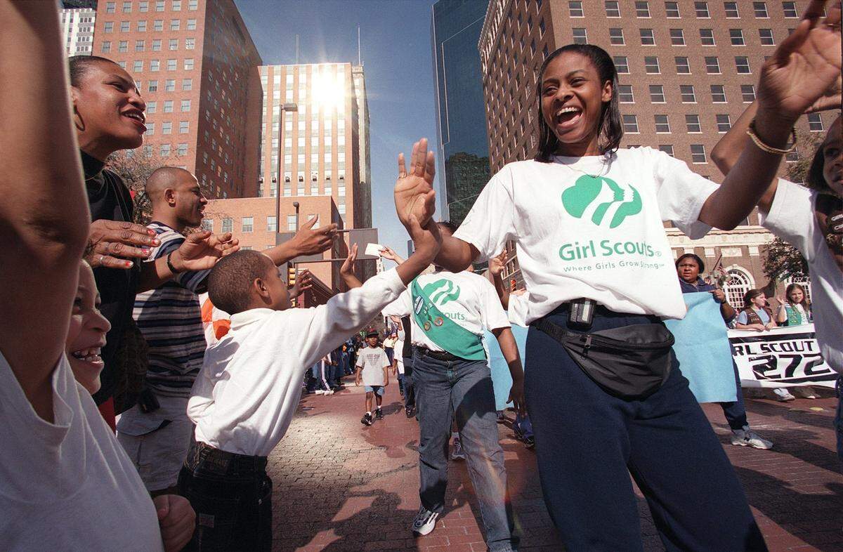 Jan. 17, 2000: Girl Scouts and parade watchers celebrate together on Main Street during the MLK parade in Fort Worth.
