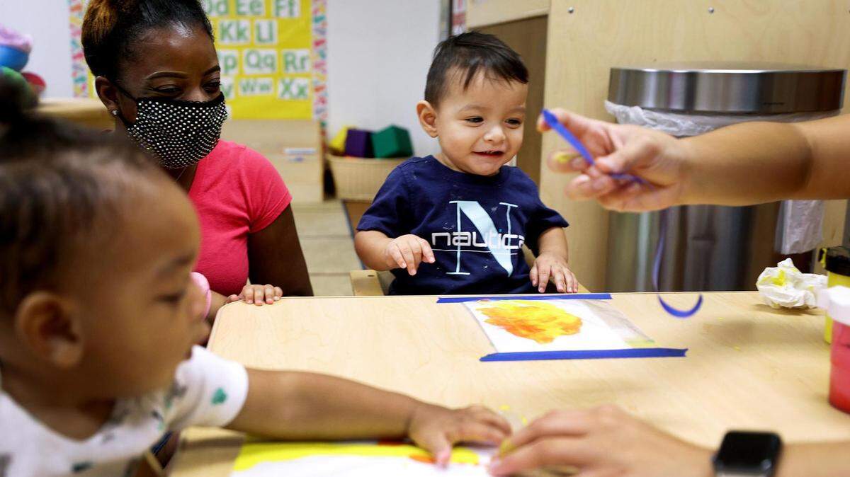 Rafael, 1, laughs while finger-painting with Early Head Start teacher Alrersha Smith, left, in Fort Worth. The Center for Transforming Lives offers full-day educational child care at no cost to eligible families.