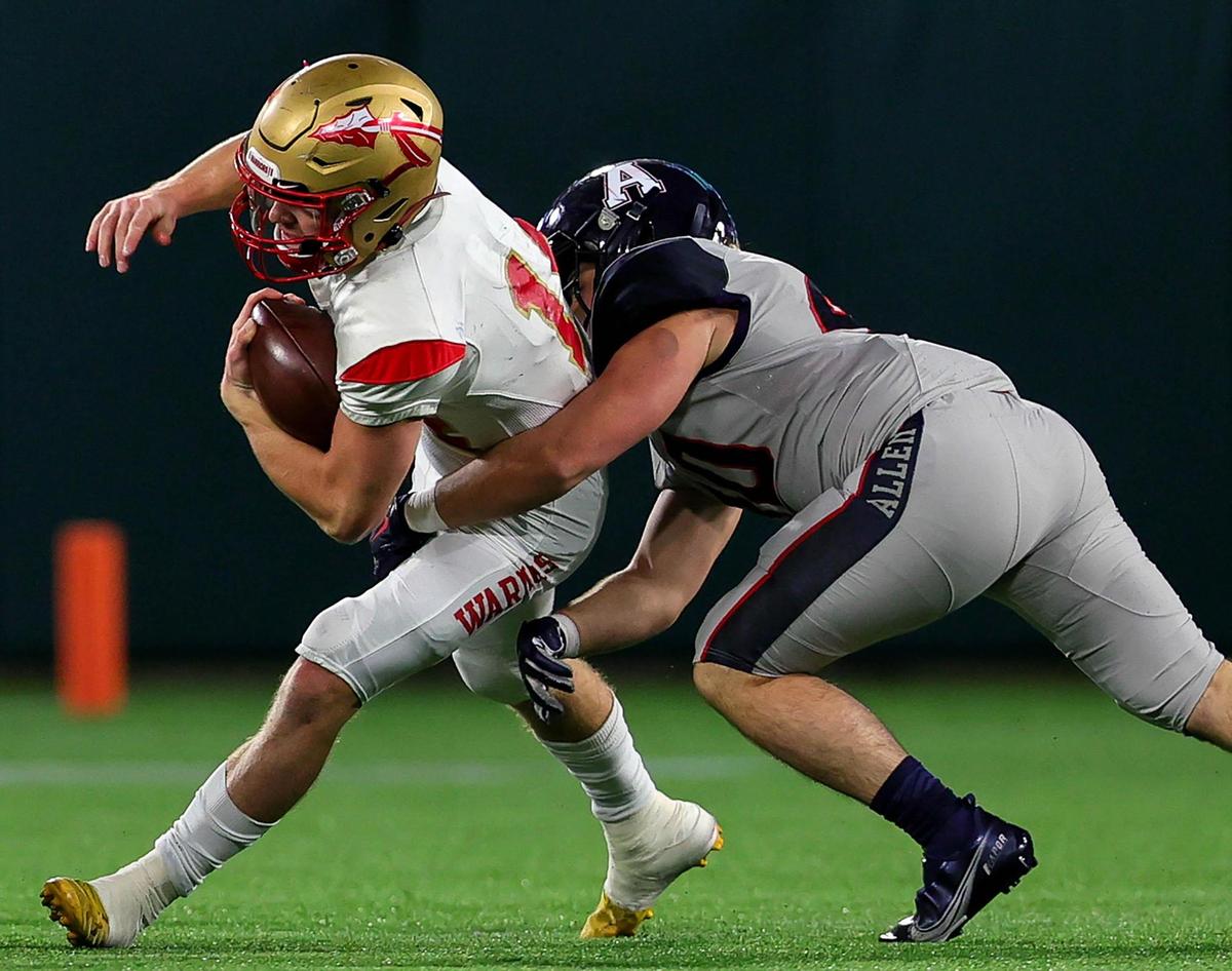 South Grand Prairie quarterback Sean Stegall (L) gets stopped for a short gain by Allen linebacker Nick Giambalvo (R) during the first half of the 6A Division I Area round high school football playoffs, December 18, 2020, played at Globe Life Park in Arlington, Tx. (Steve Nurenberg Special to the Star-Telegram)