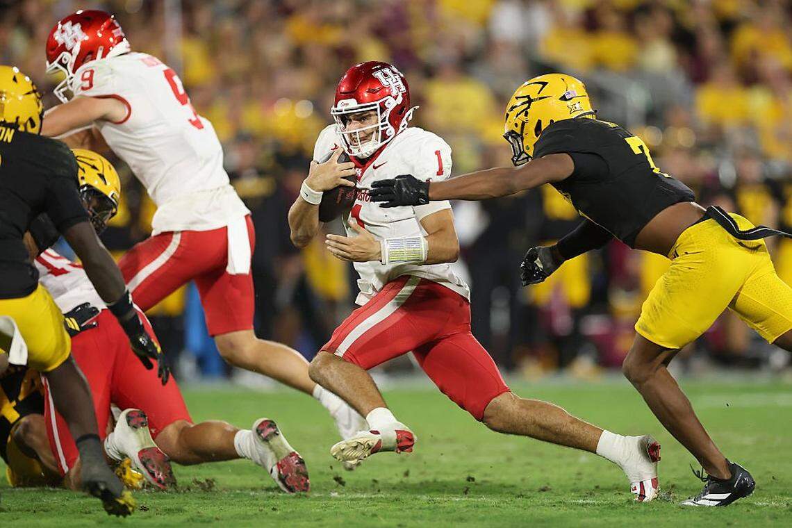 TEMPE, ARIZONA - OCTOBER 25: Conner Weigman #1 of the Houston Cougars scrambles with the football past Montana Warren #7 of the Arizona State Sun Devils during the third quarter of the NCAAF game at Mountain America Stadium on October 25, 2025 in Tempe, Arizona. The Cougars defeated the Sun Devils 24-16. (Photo by Christian Petersen/Getty Images)