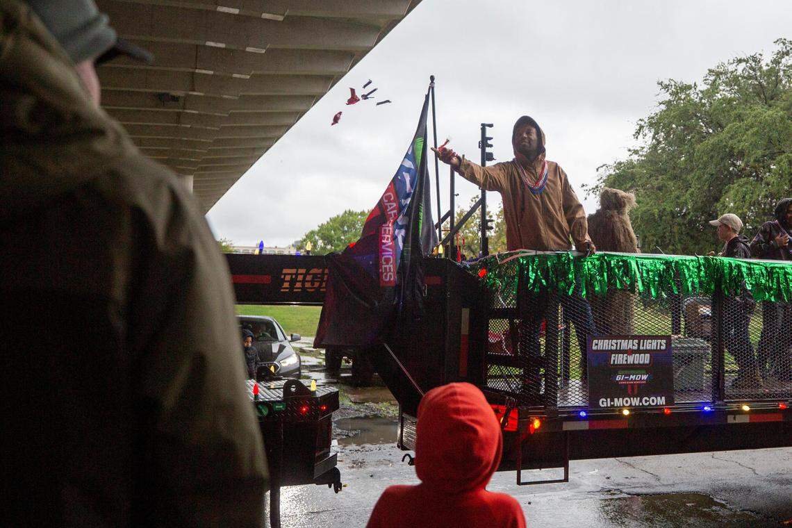 A float rider throws candy to attendants of the Veterans Day Parade winding through Fort Worth on Friday, Nov. 11, 2022. Despite rain, hundreds of participants marched down North Forest Park Boulevard, waving American flags and signing a medley of military songs.