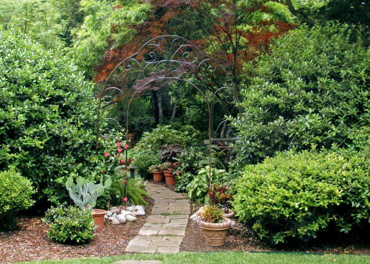 An arch adds more curves to the Sperry landscape. Walk stones made at home provide corridor into rest of landscape.