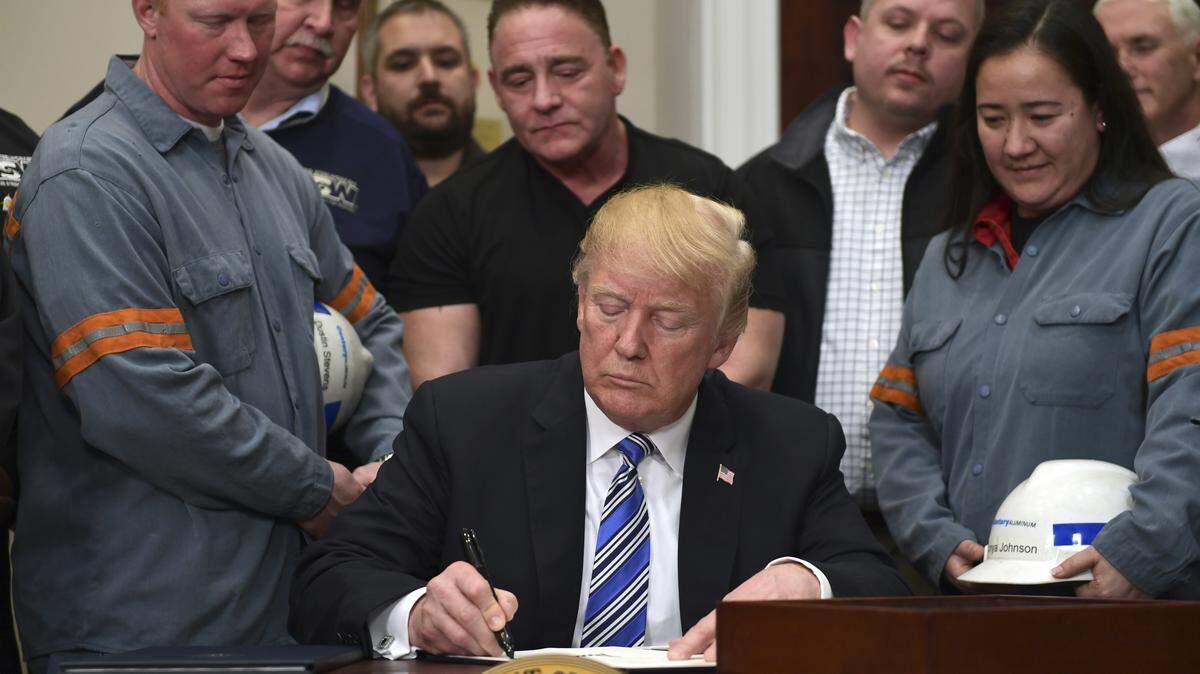 President Donald Trump signs a proclamation on steel imports during an event in the Roosevelt Room of the White House in Washington, Thursday, March 8, 2018. He also signed one for aluminum.