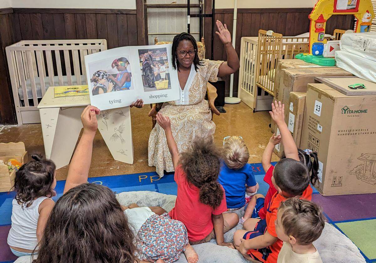 BriTanya Brown, former owner and operator of a 24/7 child care program named Our Loving Village in Stamford, reads to a mixed-age group of children in June 2023.