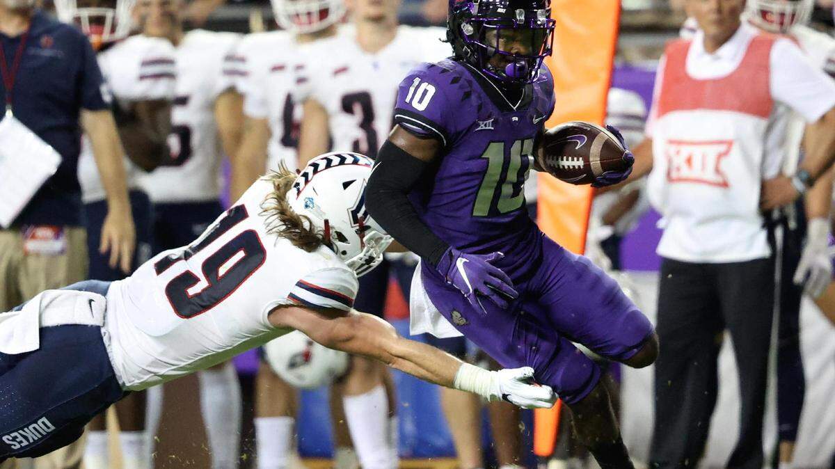 TCU receiver JD Spielman, right, being pursued by Duquesne linebacker Connor Barrett during Saturday’s opener, scored his first touchdown for the Horned Frogs in a 45-3 victory.