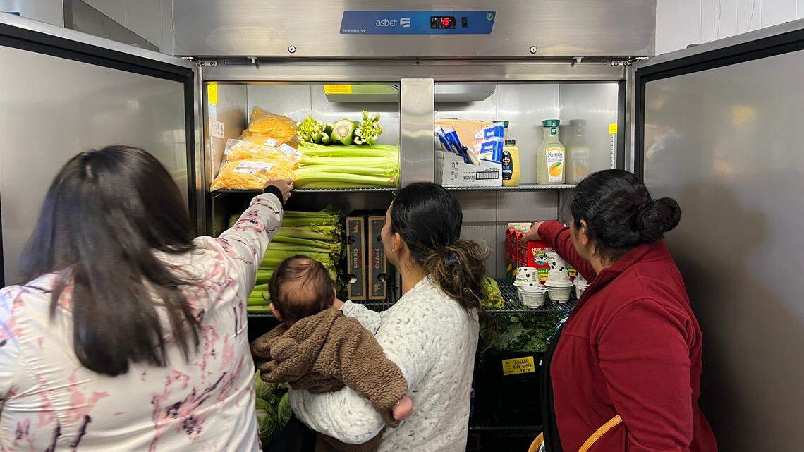 Morningside community members pick groceries from a fridge during the opening of the Viking Market at Morningside Middle School in Fort Worth on Tuesday, Feb. 6, 2024.
