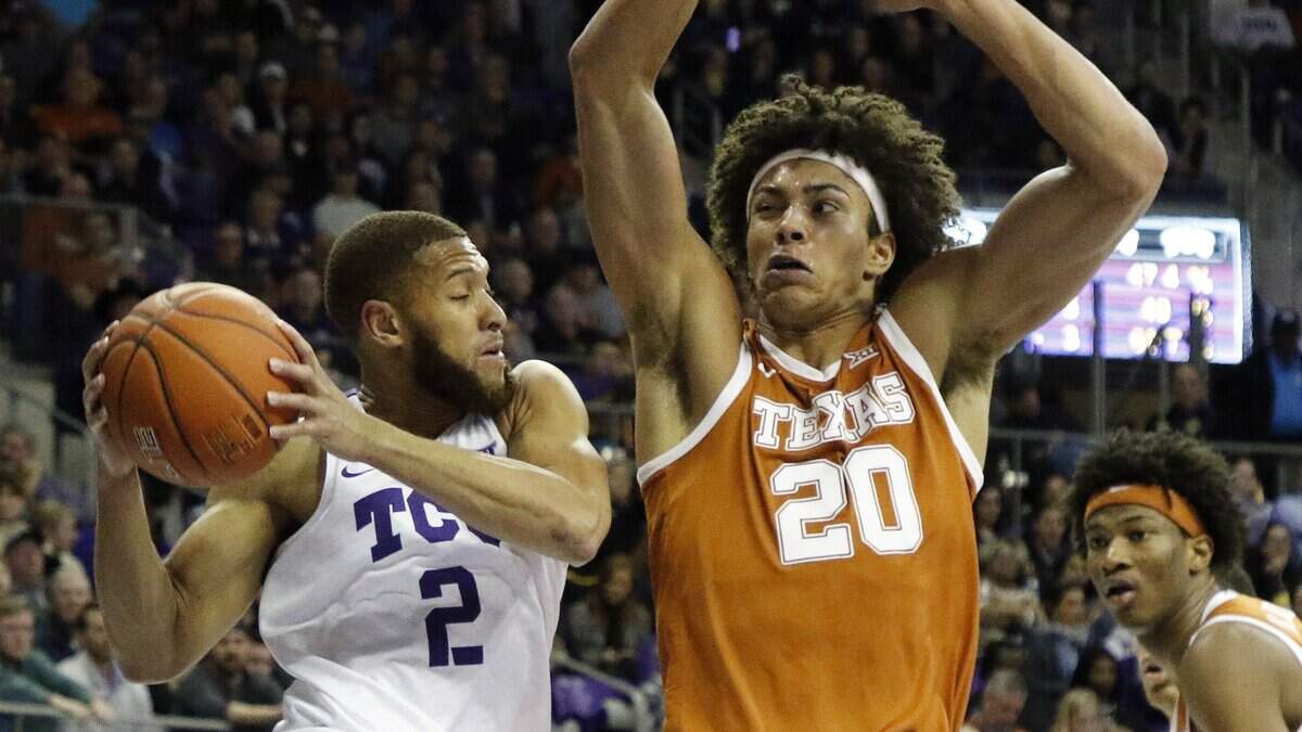 TCU guard Edric Dennis Jr. (2) passes across court in front of Texas forward Jericho Sims (20) in the first half of Wednesday’s game at Schollmaier Arena in Fort Worth. The Longhorns won 62-61.