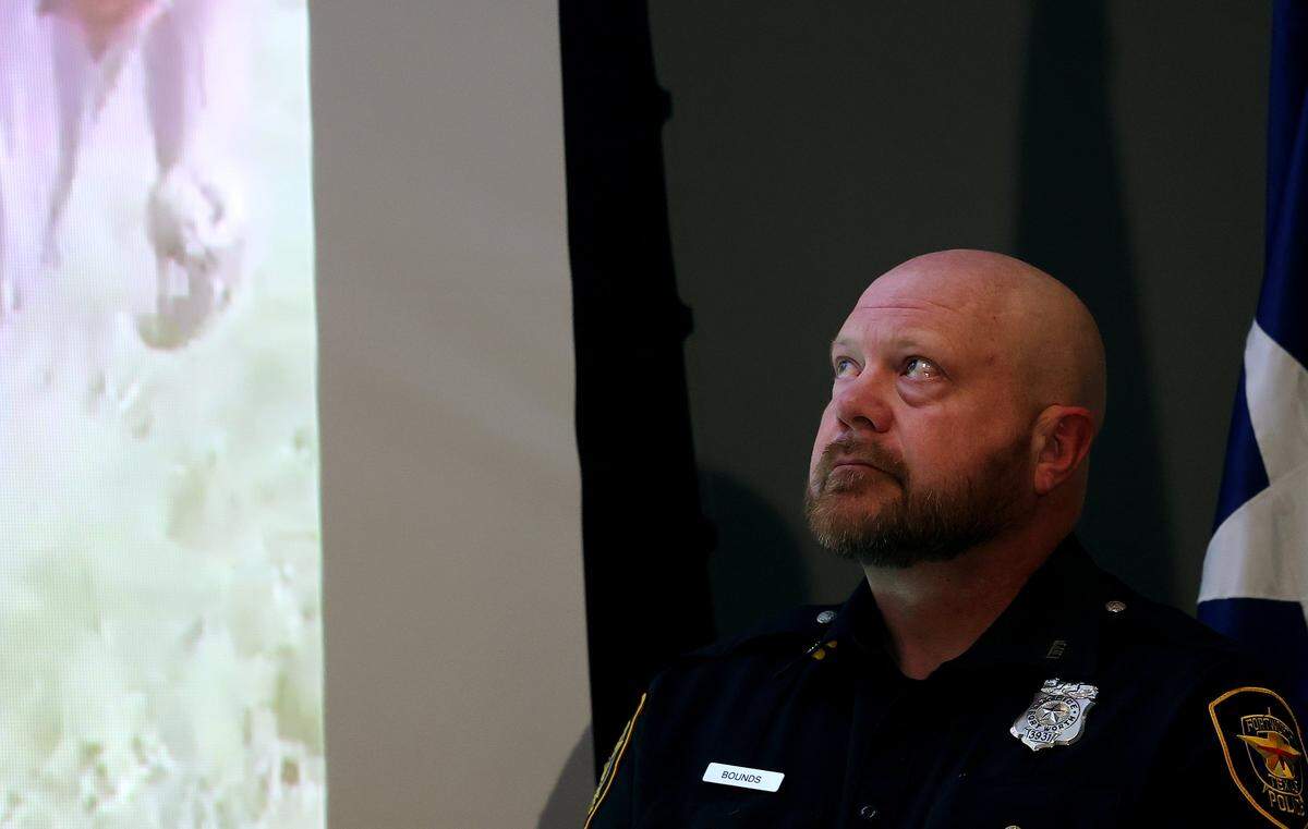 Fort Worth Police Officer Edwin Bounds watches a video of him and Sgt. Ryan Nichols saving a one-year-old child trapped under an overturned vehicle 1-year-that crashed on Interstate 30 during a press conference on Tuesday, Oct. 28, 2025.