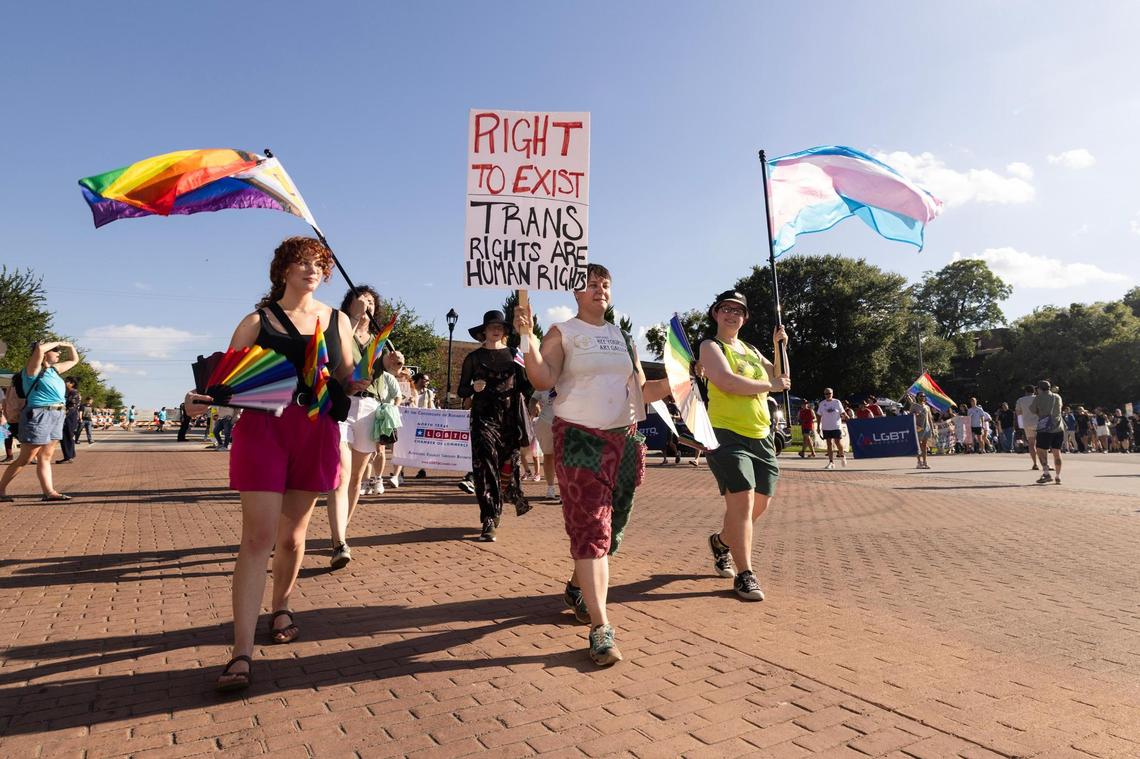 March participants walk with signs down South Main Street during Trinity Pride Fest in Fort Worth on Saturday, June 28, 2025.