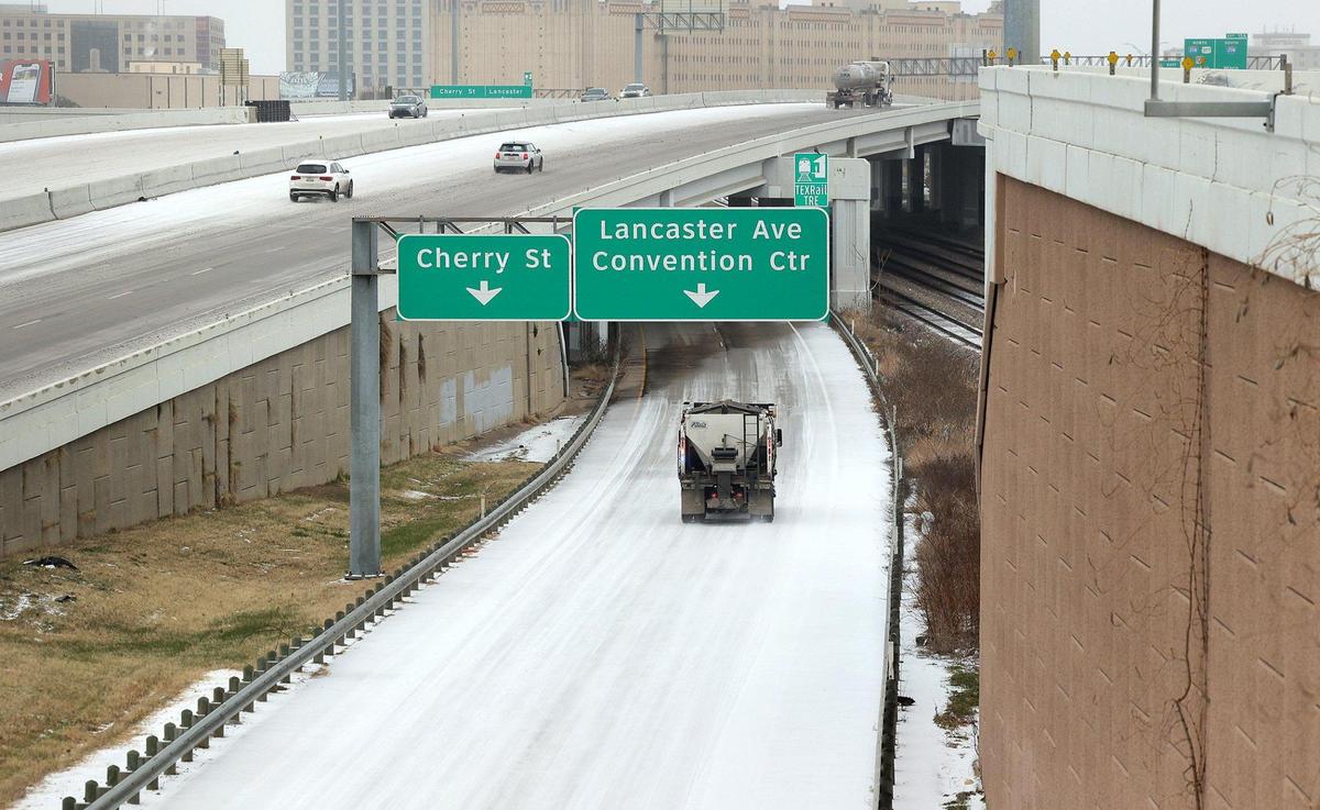 Vehicles drive on a snowy Interstate 30 and its ramps on Tuesday, January 31, 2022. The winter storm warning is extended through 6 a.m. Thursday and freezing rain is expected most of Tuesday and Wednesday, officials said.