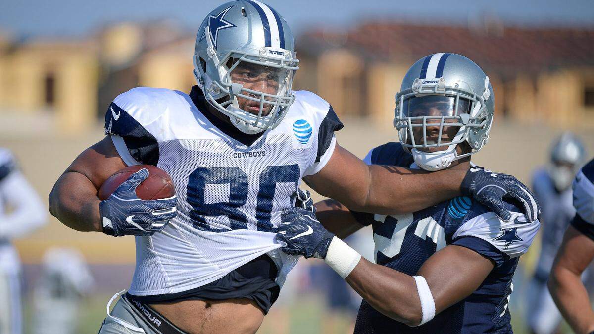 Cowboys tight end Rico Gathers, left, pushes aside defensive back Tyree Robinson on his way to the end zone during a training camp practice on Thursday in Oxnard, Calif.