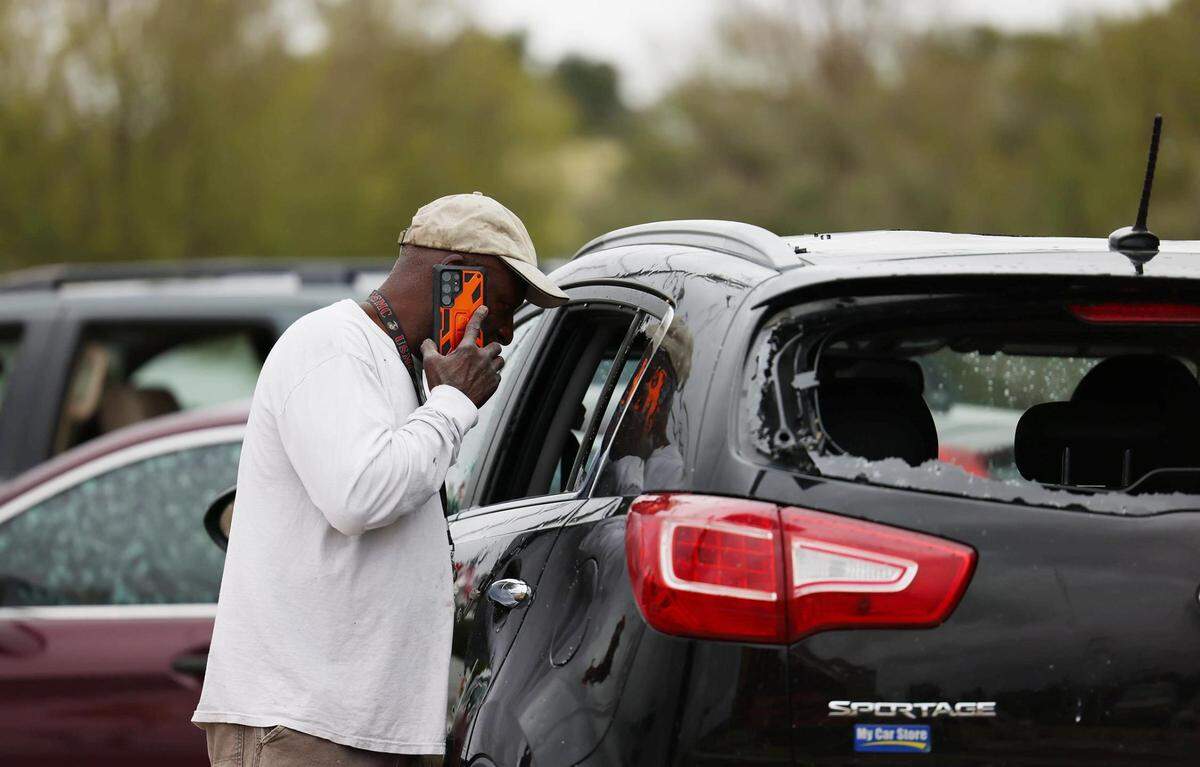 Edward Andrews, owner of Special Touch Auto Sales, looks at damage to his vehicles on Thursday, October 5, 2023, after severe thunderstorms swept through the area Wednesday evening in Fort Worth. A roof ripped off a nearby shopping center landed onto the car lot.