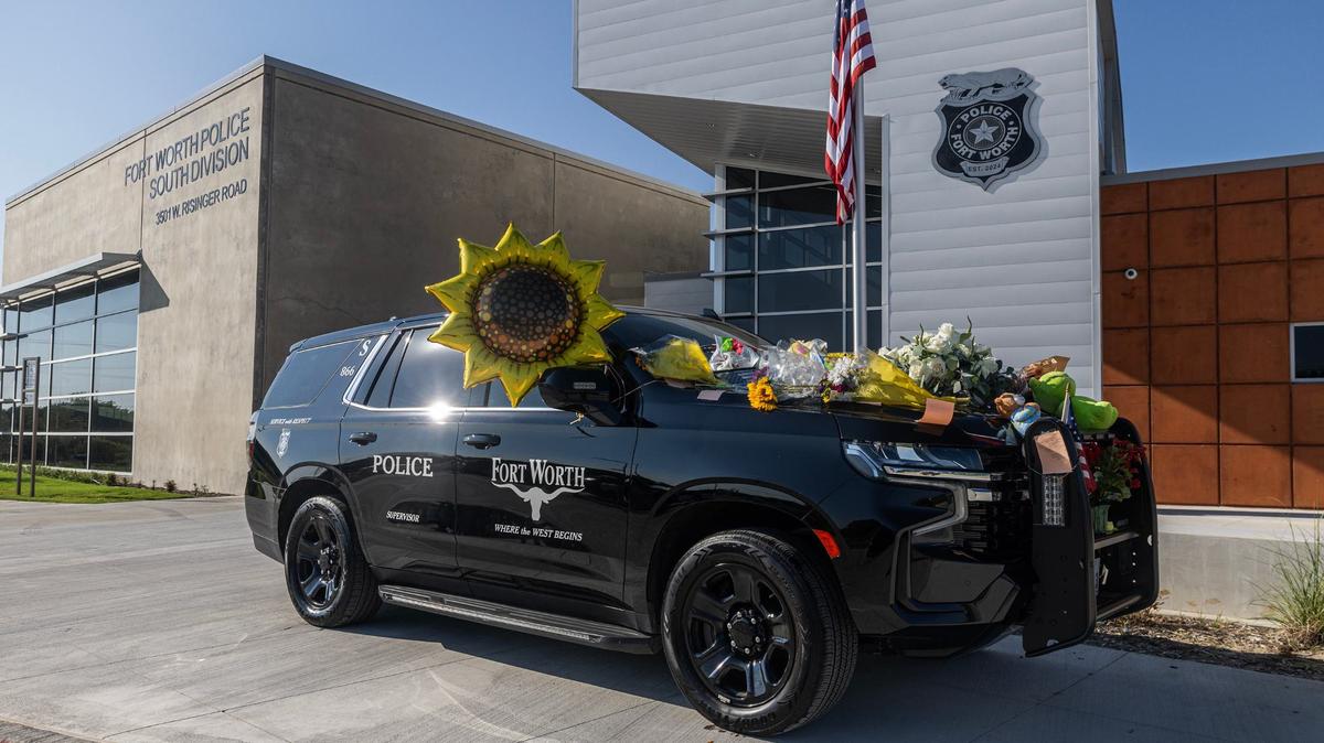 Flowers, handwritten notes and other items are placed on the patrol vehicle in memory of the late Fort Worth Police Department Sgt. Billy Randolph at Fort Worth PD South Division headquarters on Tuesday. Sgt. Randolph was struck by a vehicle while working a crash scene on the exit ramp of I-35W near Sycamore School Road on Monday morning.