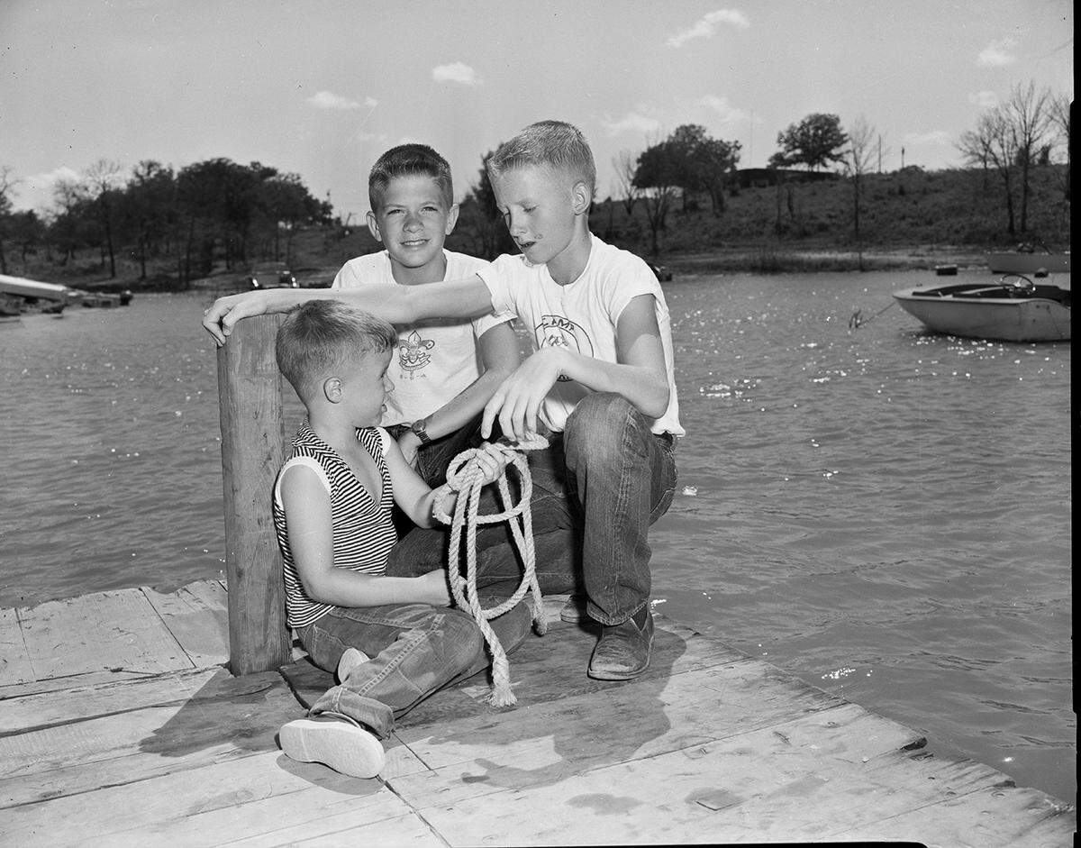 July 13, 1958: “Craig Norman, saved from downing by brother James Lee Norman. Craig, who hasn’t got his sea-legs yet, toppled off a dock into Grapevine Lake late Saturday. More used to range than the water, Craig began to flounder.”