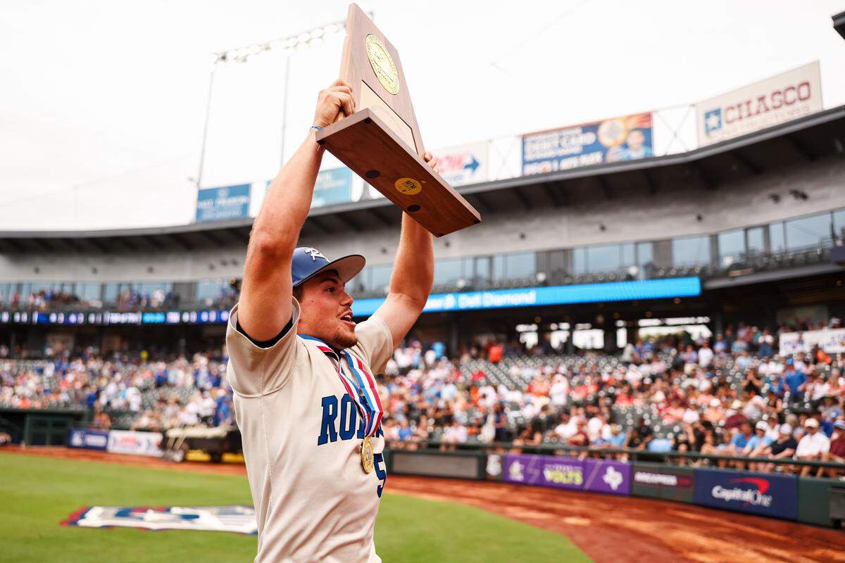 A Robinson player runs toward the stands holding the championship trophy after defeating Brock 3-1 in the UIL Class 4A Division II baseball state championship game on Friday, June 5, 2026, at Dell Diamond in Round Rock, Texas.