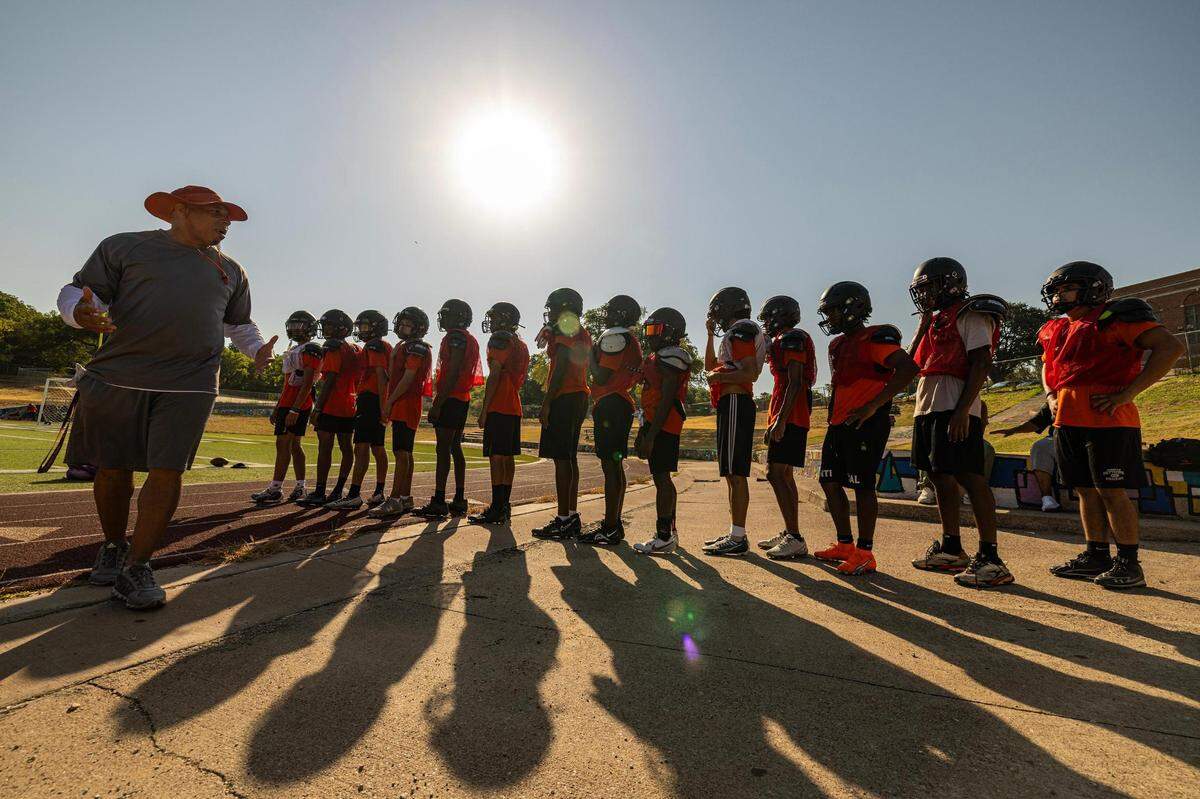 Fort Worth Polytechnic Football Assistant Coach Bennett speaks to the players prior to practice at Fort Worth Polytechnic High School in Fort Worth on Thursday morning.