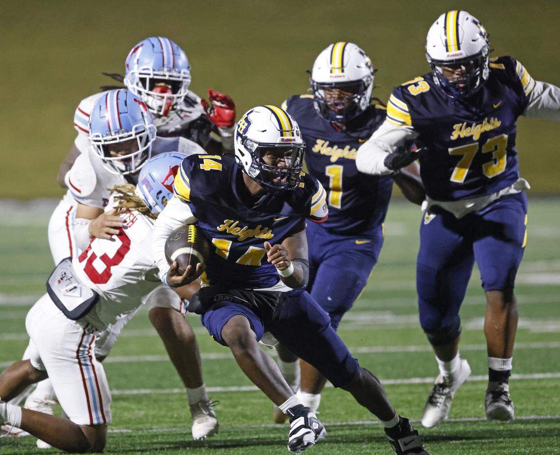 Fort Worth Arlington Heights quarterback Carmelo Carter (14) gains yardage during the first half of a UIL Class 5A DI area-round football playoff game Thursday Nov. 20, 2025 at Shotwell Stadium in Abilene, Texas.