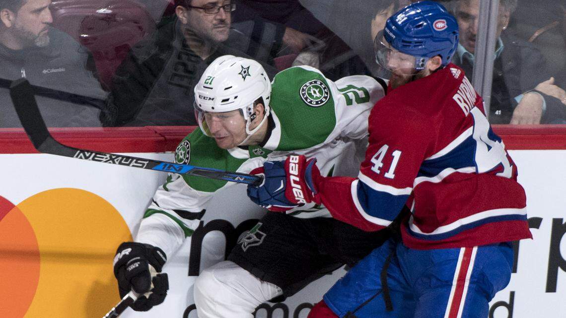 Stars left wing Antoine Roussel (21) is stopped by Montreal Canadiens left wing Paul Byron (41) during the first period of Tuesday's game.
