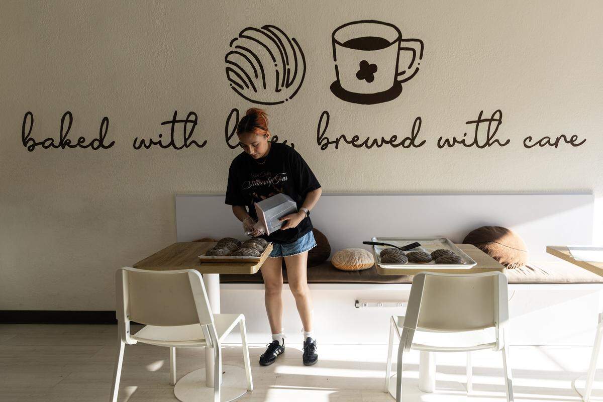 A barista pours Oreo crumble onto Oreo conchas.
