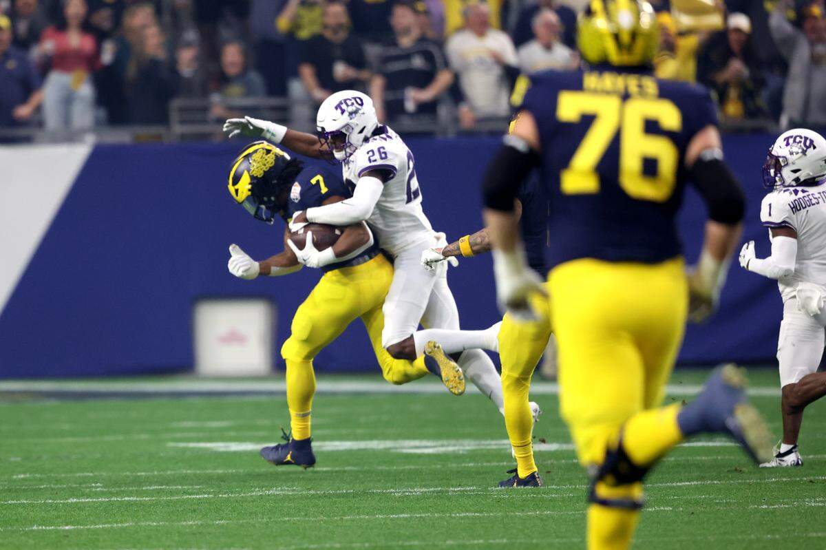 TCU safety Bud Clark tackles Michigan running back Donovan Edwards during their game against Michigan at the Vrbo Fiesta Bowl in Glendale, Ariz., on Saturday, December 31, 2022.