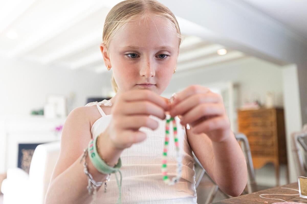 Coco Grieshaber, 8, of Fort Worth creates a custom-made bracelet in her home on Tuesday, July 15. The Grieshaber family is selling bracelets to raise money for the families affected by the flooding near Kerrville, Texas.