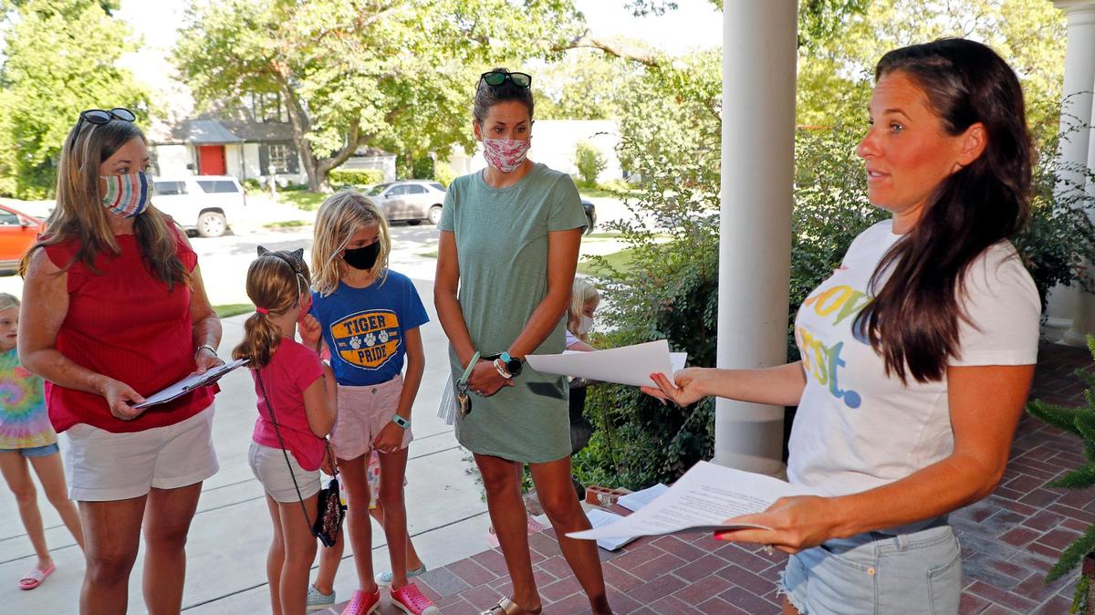Katie Stadler instructs volunteers, including Sasha Denman and Marissa Kelly, how and where to place protest notifications in Fort Worth, Friday, Aug. 14, 2020. About a dozen adults with children passed out protest notifications in several Fort Worth schools.