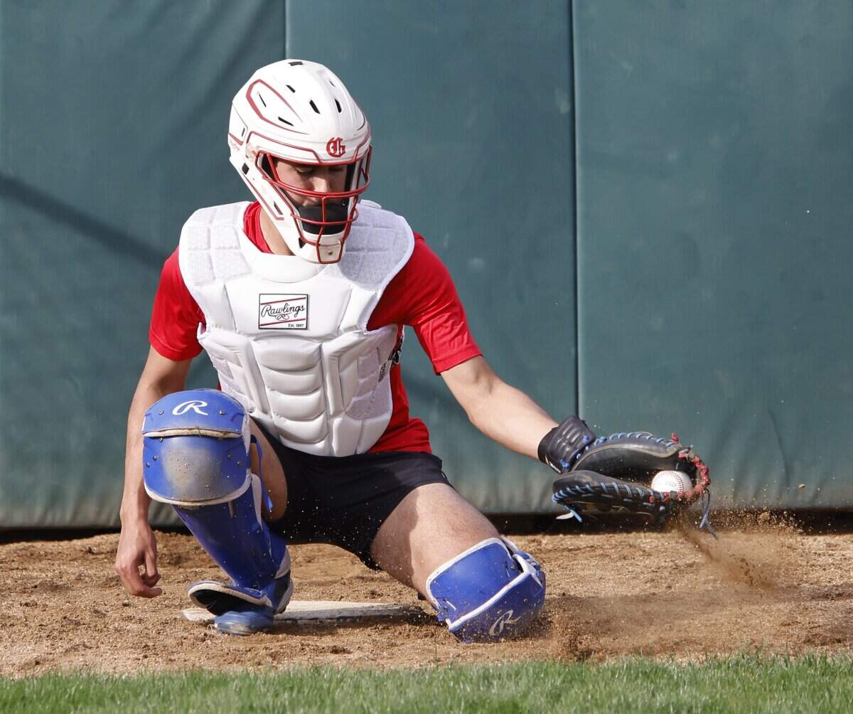 Grapevine catcher Gianni Corral picks one out of the dirt in the pitching cage during Grapevine Mustang baseball practice at Grapevine High School in Grapevine, Texas, Tuesday Feb. 17, 2026.
