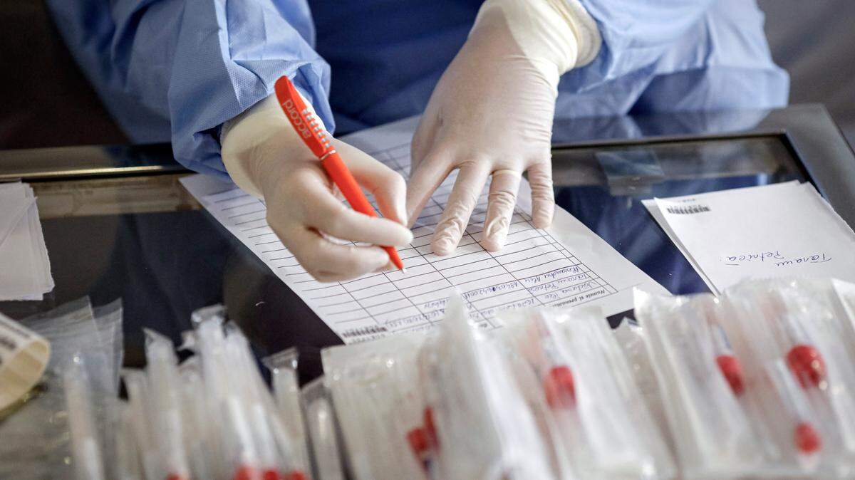 A health official prepares to take samples for a coronavirus test from a journalist in Bucharest, Romania, Friday, March 13, 2020 after it was confirmed that a senator who attended several meetings in the building tested positive for the infection. The caretaker prime minister of Romania, Ludovic Orban, said in a press conference at the parliament, the government, including all ministers, as well as the leadership of the ruling National Liberal Party and all its senators, are going into quarantine after one of the governing party’s senators, who took part in high-level meetings, who confirmed to be infected with the coronavirus. (AP Photo/George Calin)