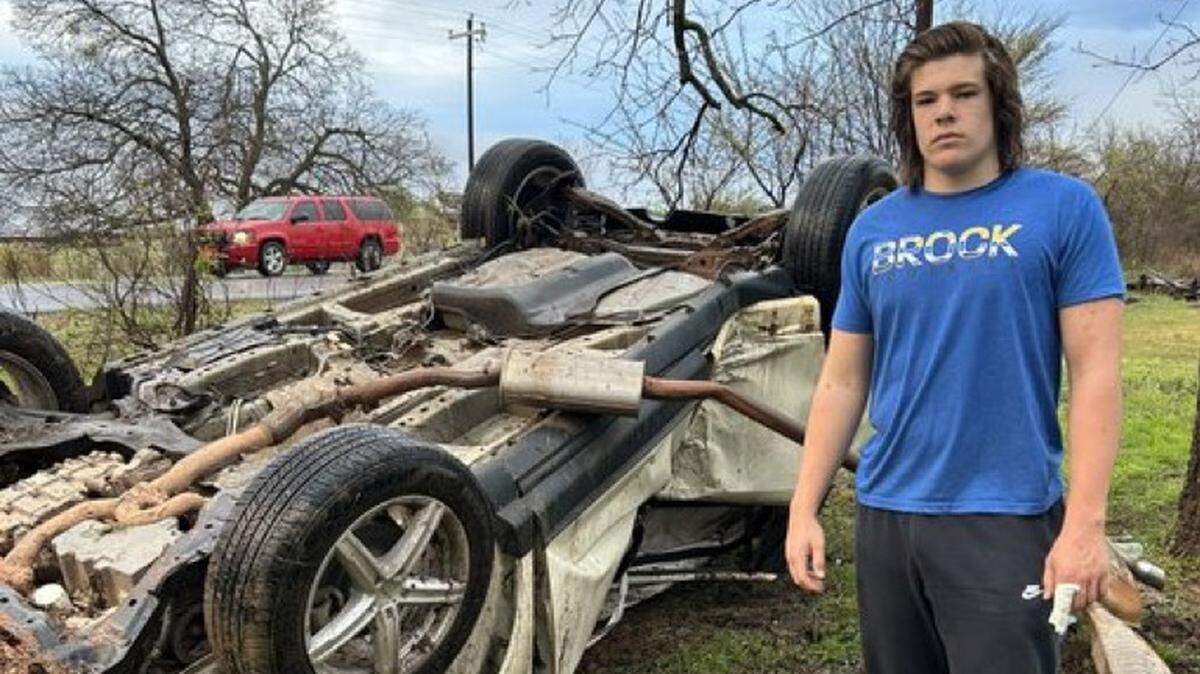 Brock Riker stands outside the wreckage of a car crash on March 24, 2023.
