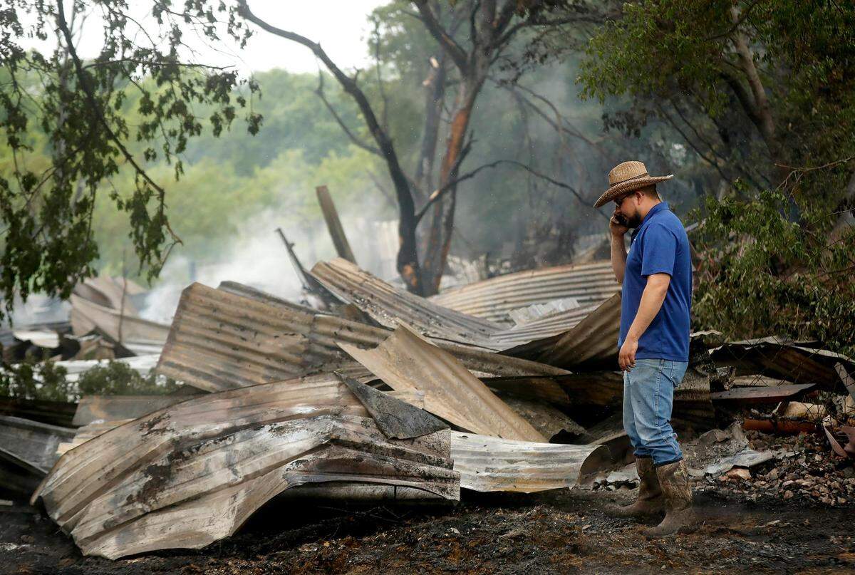 Adrian Castillo looks over what remains of his family’s horse stable on Wednesday, April 24, 2019, in Fort Worth. Several train cars derailed early Wednesday and caught fire. The fire spread to a nearby horse stable on Atkins Street, causing complete devastation and killing three horses.