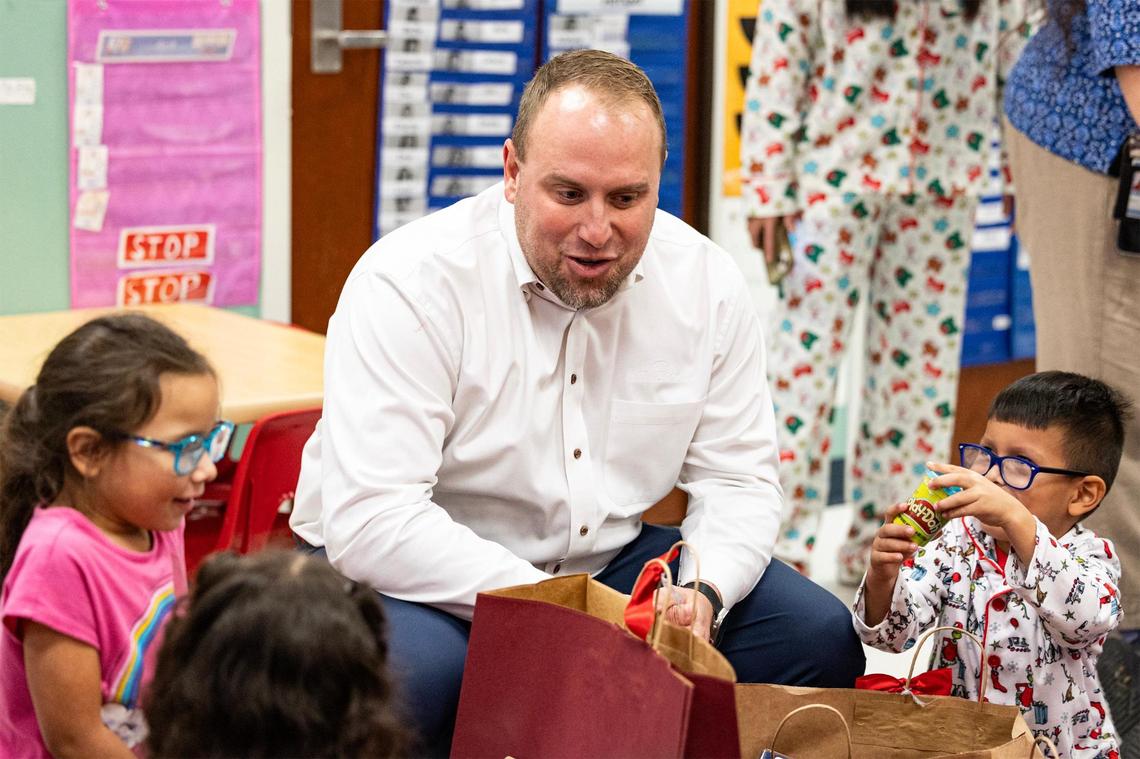 Ryon Ray, the president and CEO of NT Window, speaks to kindergarten students opening their Christmas presents in Sandra Keefe’s classroom at Alice Contreras Elementary School in Fort Worth on Thursday, Dec. 19, 2024.