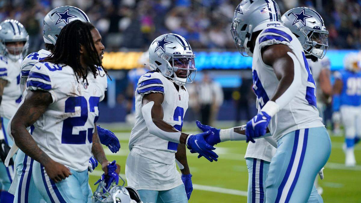 Dallas Cowboys’ KaVontae Turpin, center, shakes hands with teammates after returning a punt for a touchdown against the Chargers on Sunday in Los Angeles.