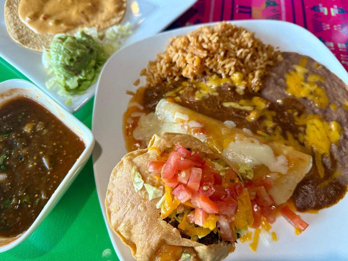 An old-timey combination plate at Dos Amores, formerly Miguelito’s, has cheese and chicken enchiladas, rice, beans, a puffed taco, guacamole, a chile con queso tostada plus the hotter diablo sauce, bottom left.
