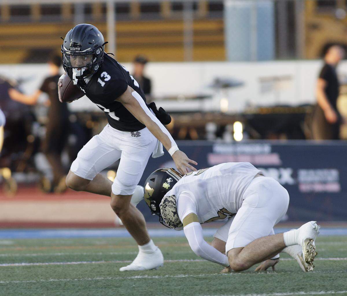 Arlington Martin’s Chase Devoll (13) escapes a tackle against Mansfield during their game on Thursday, September 11, 2025 at Maverick Stadium in Arlington Texas.