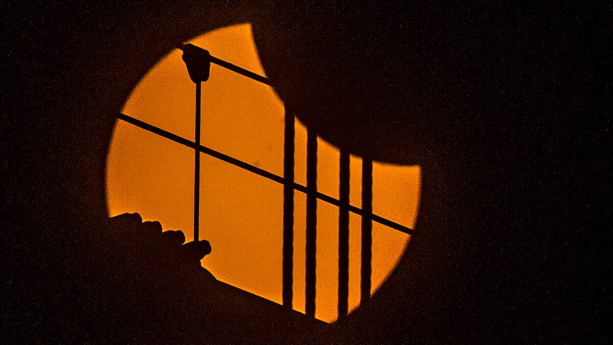 Cables from the Tacoma Narrows Bridge in Washington are silhouetted on the sun as the total solar eclipse on Aug. 21, 2017, began. Special glasses or filters are needed to view a solar eclipse.