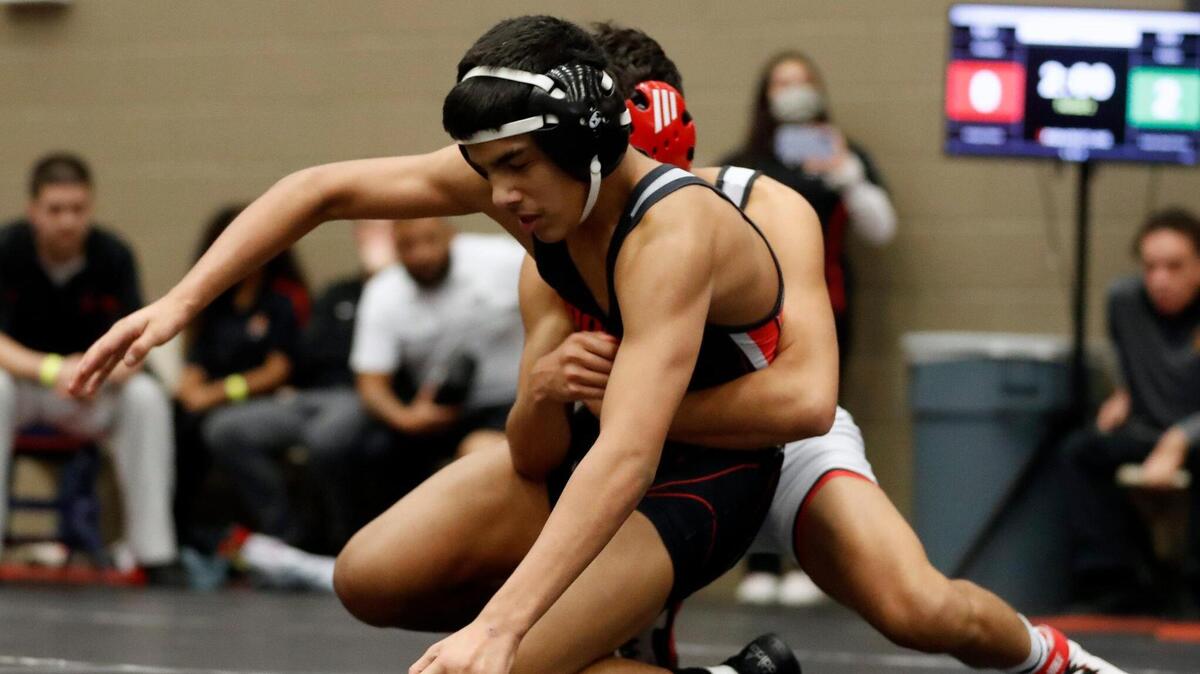 Arlington Martin’s Isaak Arevalo is grabbed from behind by South Grand Prairie’s Ivan Lopez during the 2022 state wrestling championships. It was the beginning of his four straight state titles. 