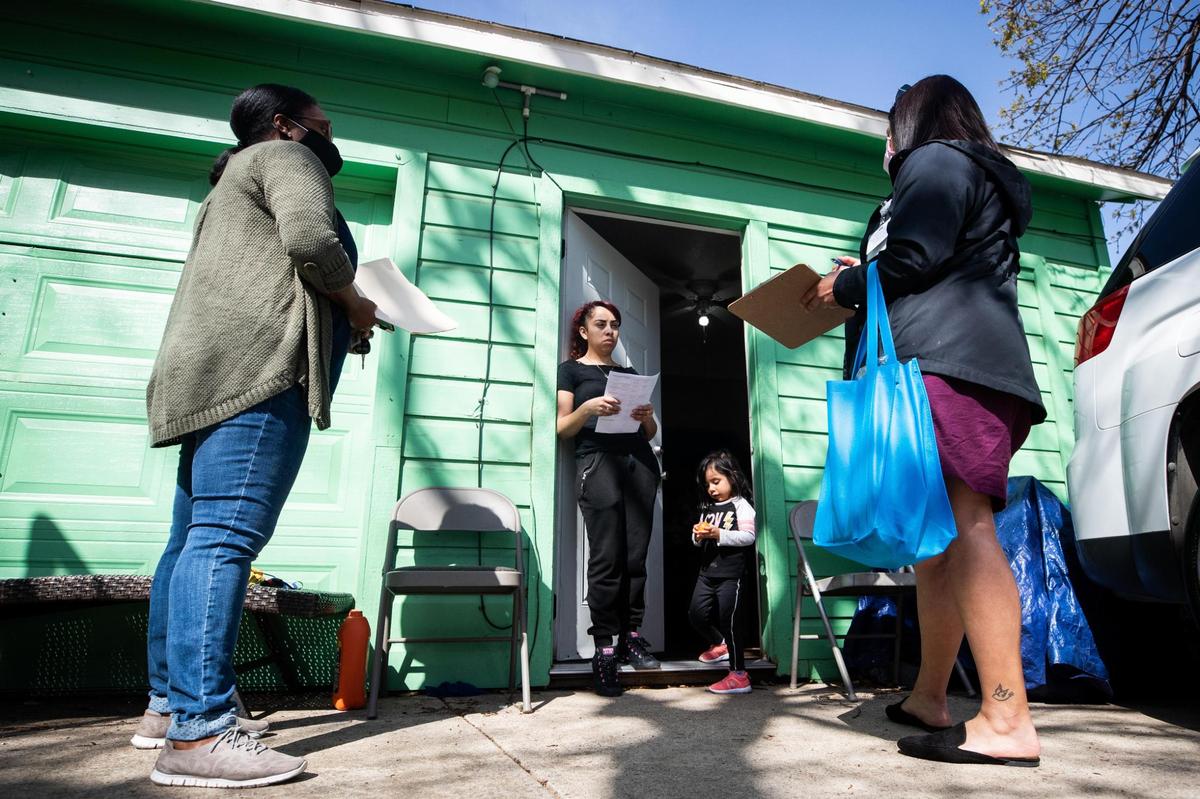 LaShun Cabness, left, a family and community partnership manager at Oakhurst Elementary School, and Anabel Montes, a service coordinator with MHMR Tarrant County, chat with Viridiana Meza and her daughter Madelyn Sanchez, 3, about her son who attends Oakhurst on Wednesday, March 24, 2021, in Fort Worth. MHMR and Fort Worth ISD teamed up to do visits in an effort to reach students who are disengaged from school during the pandemic.