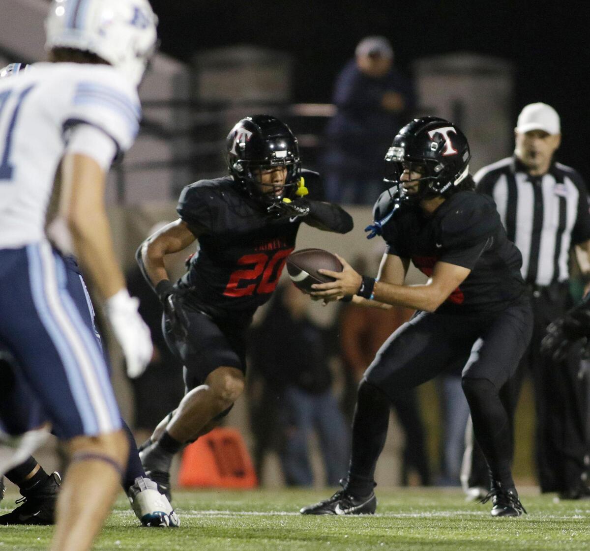 Trinity’s TJ Tupou hands off to Josh Bell during a UIL football game at Pennington Field on Thursday, November 7, 2024.