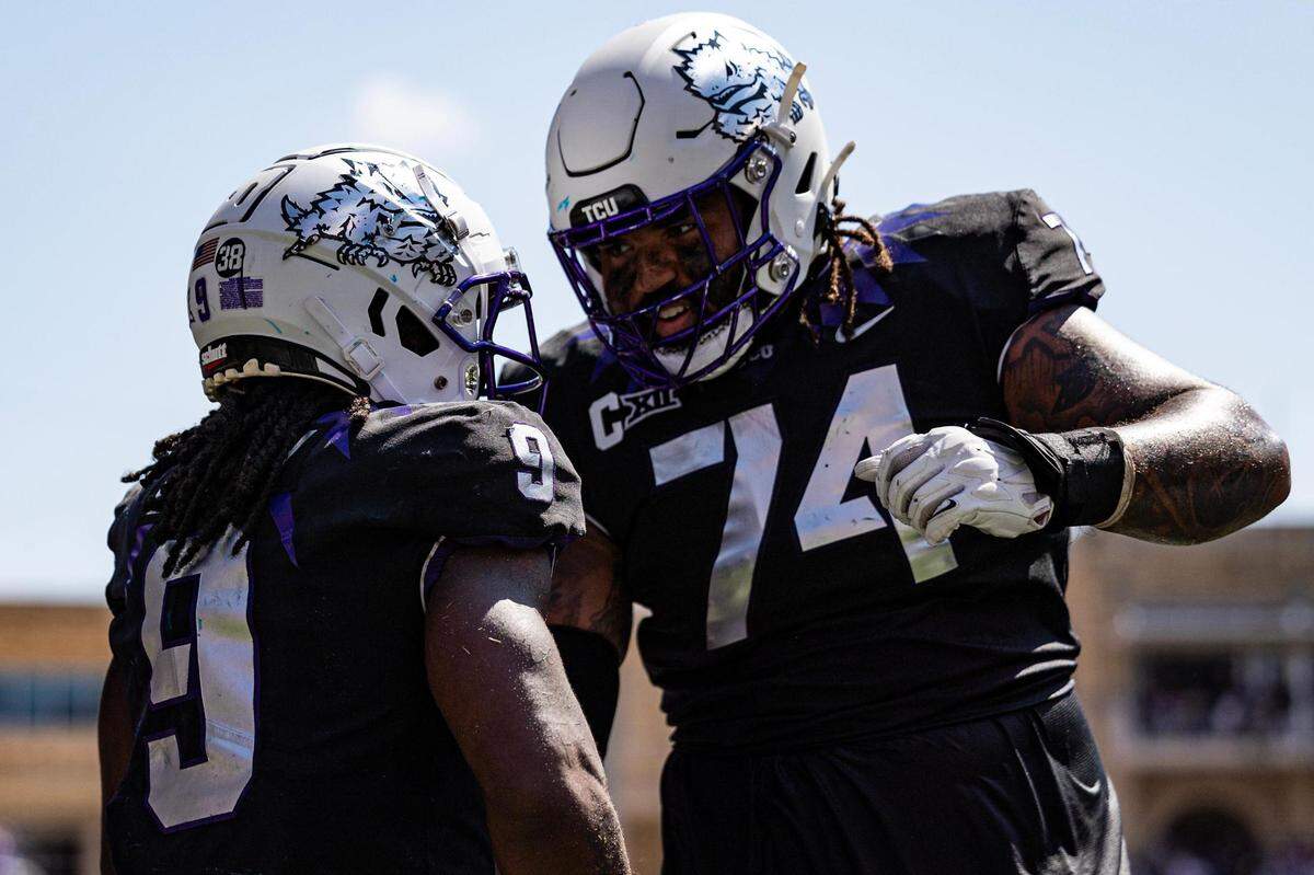 TCU running back Emani Bailey (9) celebrates with offensive lineman Andrew Coker (74) after scoring a touchdown in the second half of a BIG 12 football game between the TCU Horned Frogs and the SMU Mustangs at Amon G. Carter Stadium in Fort Worth on Saturday, Sept. 23, 2023.