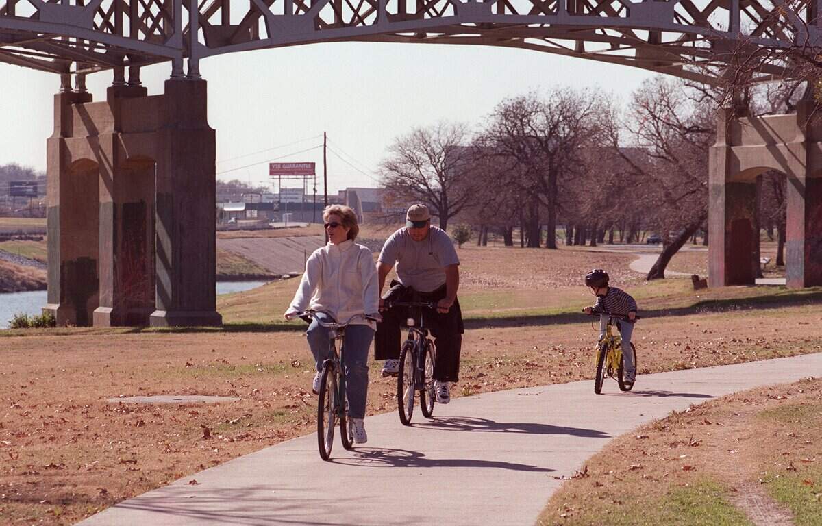 Vicki Holland and Stan Holland, along with Cody Moon, 7, enjoy their New Year's Day bike ride at Trinity Park in Fort Worth.